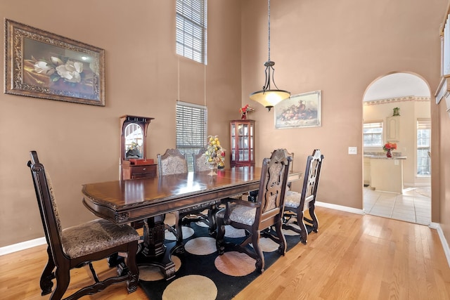 dining room featuring a high ceiling and light hardwood / wood-style floors