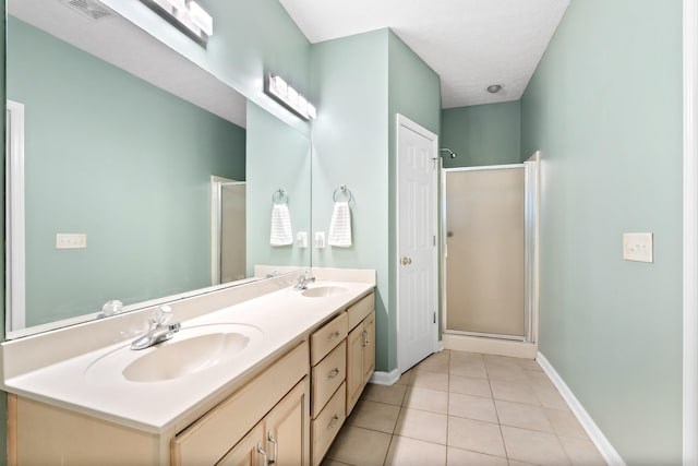 bathroom with tile patterned floors, a shower with door, and vanity