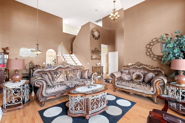 living room with a chandelier, wood-type flooring, and a high ceiling