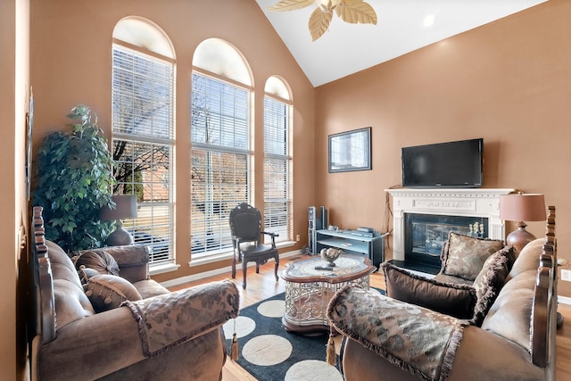 living room featuring wood-type flooring, high vaulted ceiling, ceiling fan, and a healthy amount of sunlight