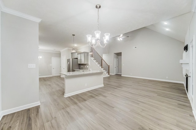 unfurnished living room with light wood-type flooring, a fireplace, crown molding, and baseboards