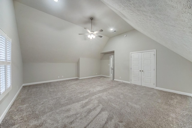 additional living space with carpet floors, ceiling fan, baseboards, and a textured ceiling