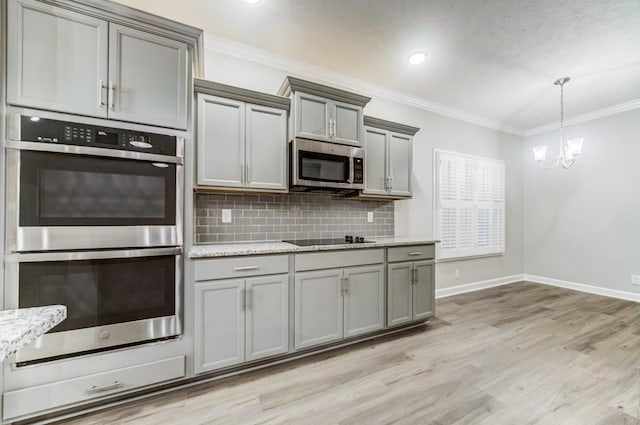 kitchen featuring light wood finished floors, tasteful backsplash, ornamental molding, gray cabinets, and stainless steel appliances