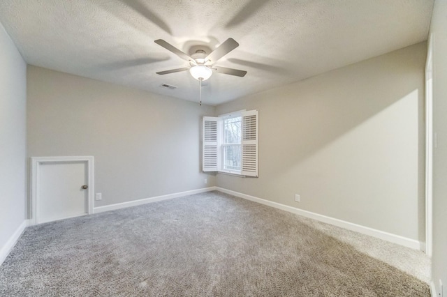 carpeted empty room featuring baseboards, visible vents, ceiling fan, and a textured ceiling