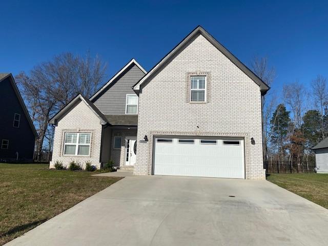 view of front of home with a garage, brick siding, concrete driveway, and a front yard