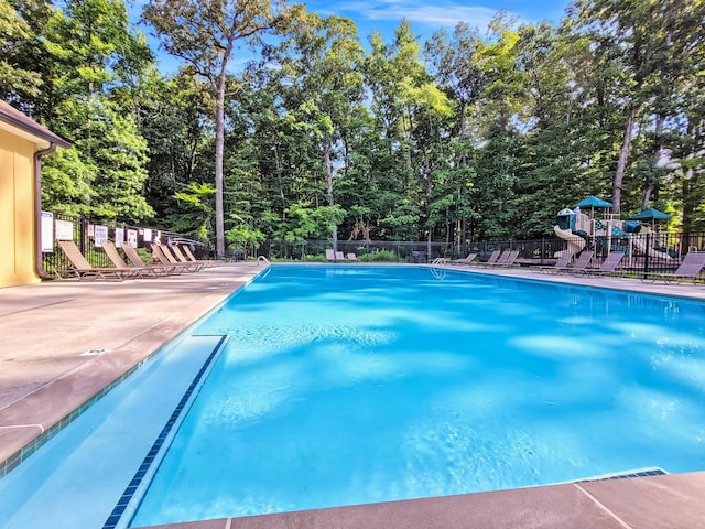 pool featuring fence and a patio