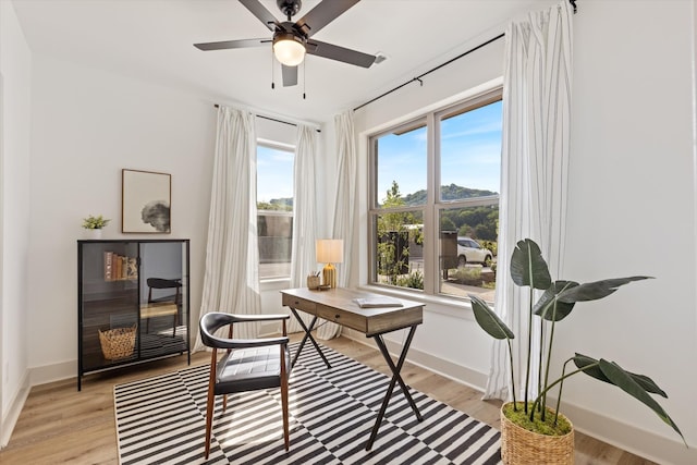 living area with ceiling fan and light wood-type flooring