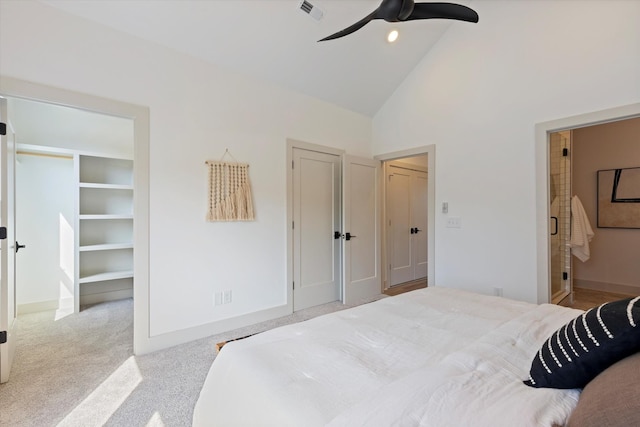 bedroom featuring ceiling fan, ensuite bathroom, high vaulted ceiling, and light carpet