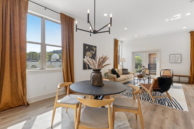 dining area with an inviting chandelier, french doors, and light hardwood / wood-style flooring