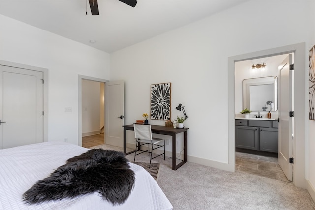 carpeted bedroom with connected bathroom, ceiling fan, and sink