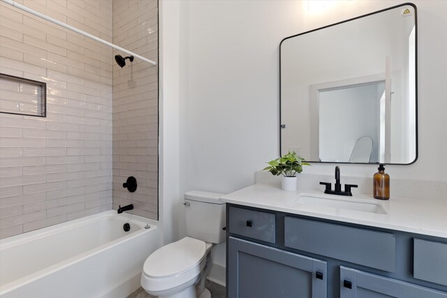 full bathroom featuring vanity, tiled shower / bath combo, and toilet