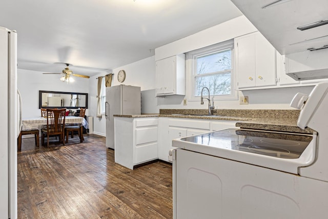 kitchen with white cabinets, sink, dark hardwood / wood-style floors, fridge, and white fridge