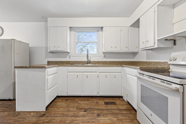 kitchen with white cabinetry, sink, dark hardwood / wood-style floors, dark stone counters, and white appliances