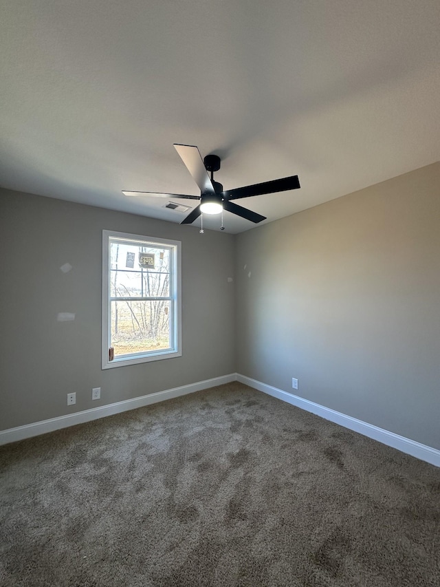 spare room with carpet floors, baseboards, visible vents, and ceiling fan