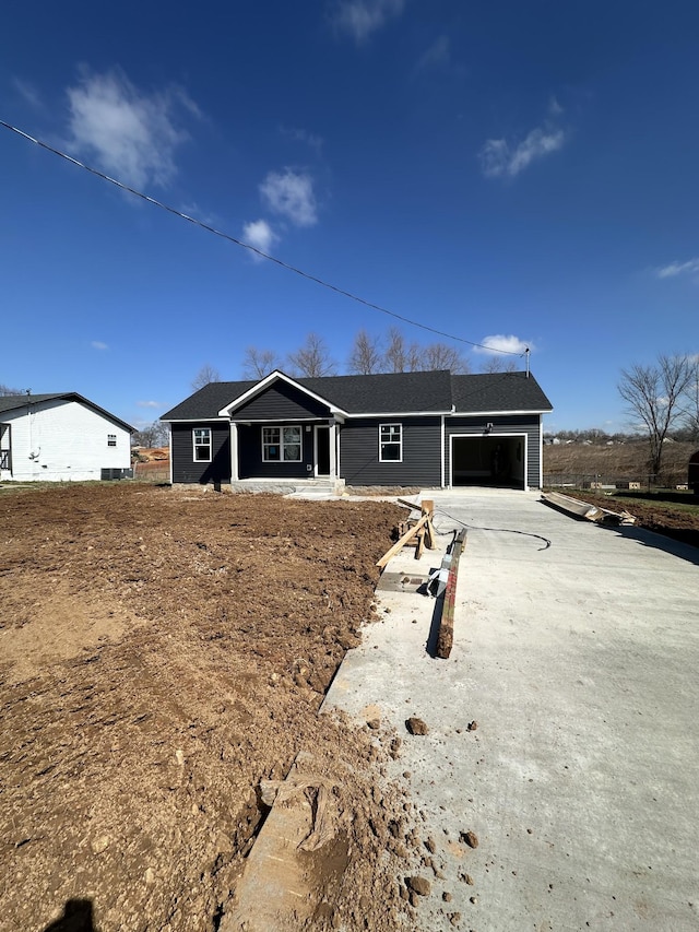 ranch-style house featuring concrete driveway and an attached garage