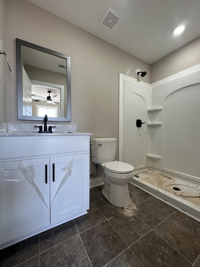 bathroom featuring visible vents, vanity, toilet, and a walk in shower