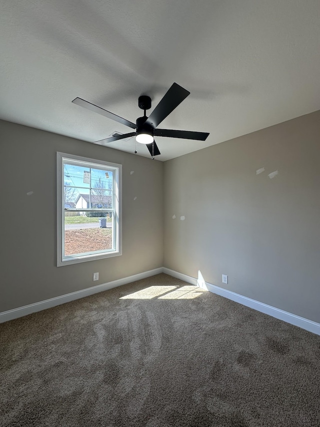 unfurnished room featuring carpet, a ceiling fan, and baseboards