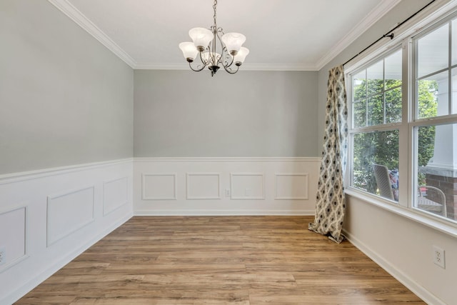 unfurnished room featuring crown molding, a chandelier, and light hardwood / wood-style floors