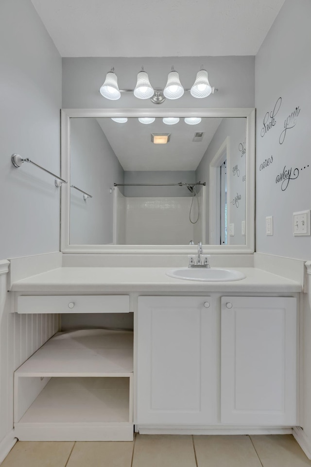 bathroom featuring vanity, tile patterned floors, and walk in shower