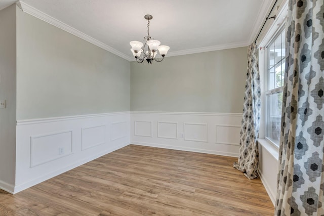 unfurnished room featuring light hardwood / wood-style floors, ornamental molding, and a chandelier