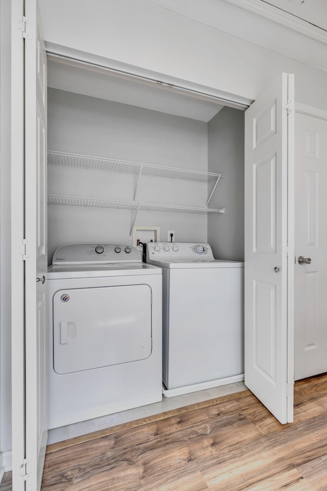 laundry room featuring light wood-type flooring and washing machine and clothes dryer