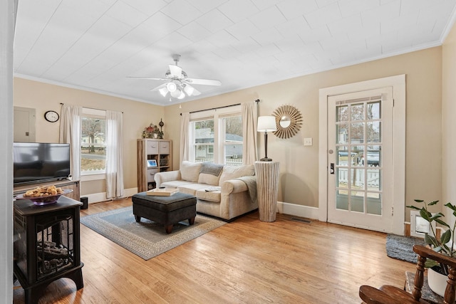 living room with light hardwood / wood-style floors, ceiling fan, and crown molding