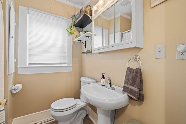 bathroom featuring crown molding, sink, and toilet