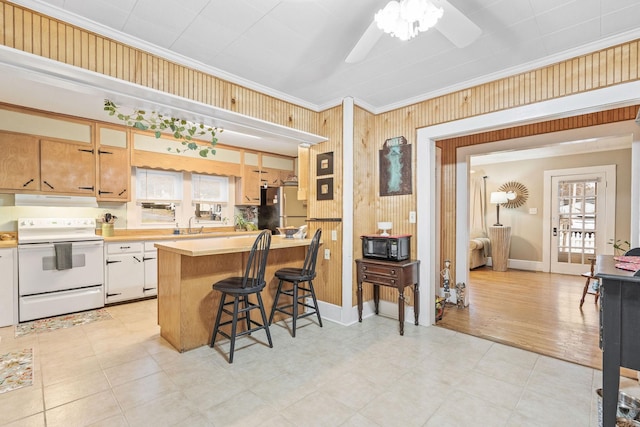 kitchen featuring crown molding, white electric stove, light hardwood / wood-style floors, a breakfast bar area, and stainless steel refrigerator