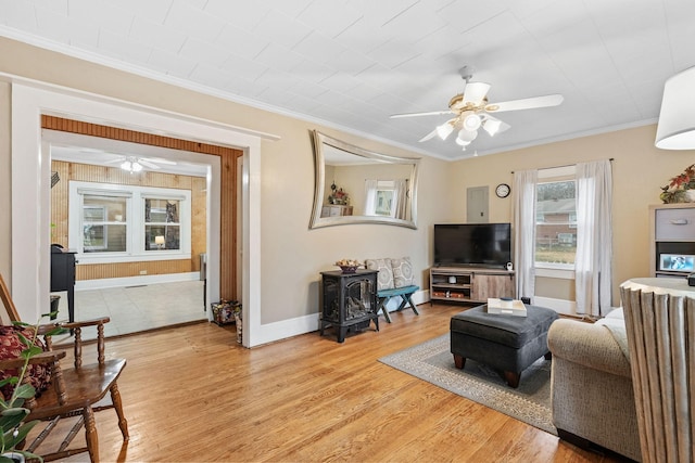 living room featuring ceiling fan, ornamental molding, and light wood-type flooring