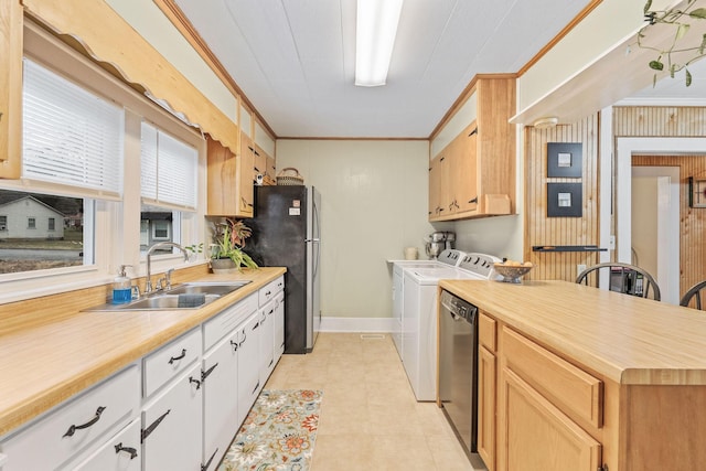 kitchen with washer and dryer, white cabinetry, sink, and ornamental molding