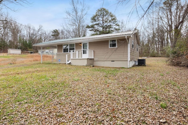 view of front of home with a front lawn, a carport, and cooling unit