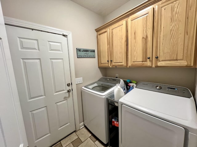 laundry area featuring washer and clothes dryer and cabinets