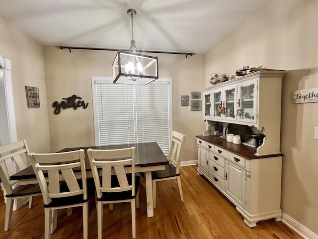 dining room with light hardwood / wood-style floors and an inviting chandelier