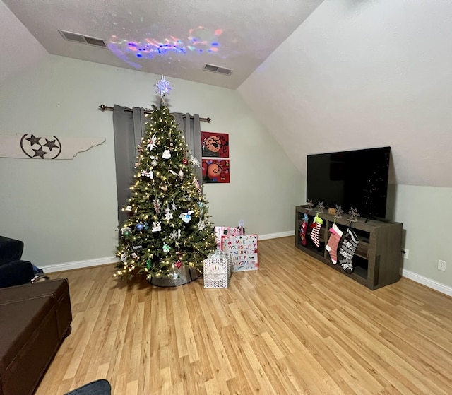 rec room featuring vaulted ceiling and light wood-type flooring