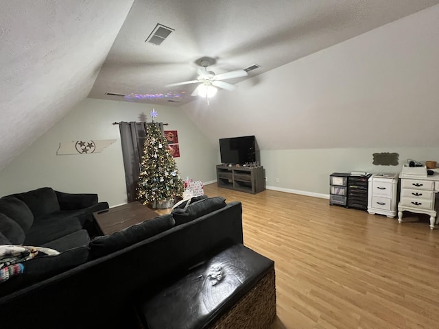 living room with hardwood / wood-style flooring, ceiling fan, a textured ceiling, and vaulted ceiling