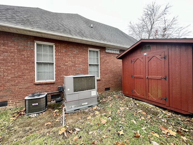 back of house featuring a storage unit and central air condition unit