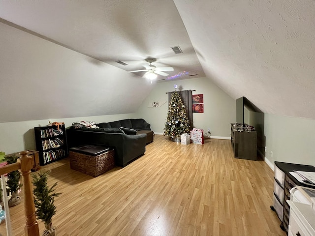 interior space with a textured ceiling, light hardwood / wood-style floors, ceiling fan, and lofted ceiling