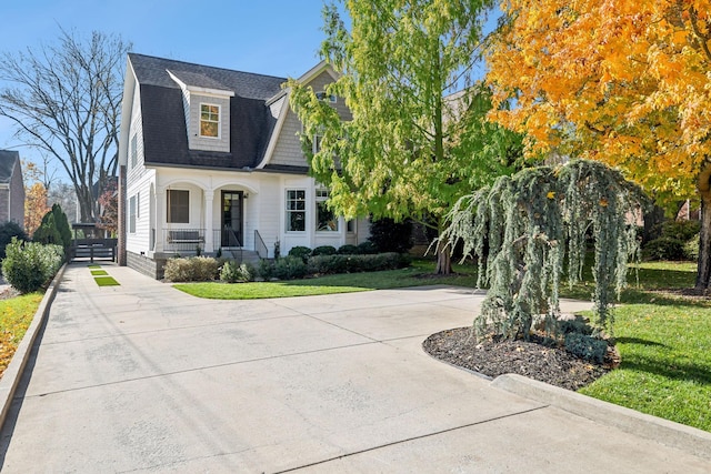 view of front of home with covered porch and a front lawn