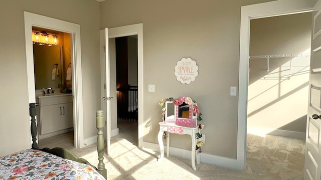 bedroom featuring light colored carpet and connected bathroom