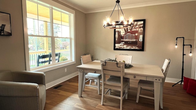 dining space featuring hardwood / wood-style flooring, an inviting chandelier, plenty of natural light, and crown molding