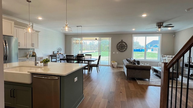 kitchen featuring sink, dark hardwood / wood-style floors, decorative light fixtures, white cabinets, and appliances with stainless steel finishes