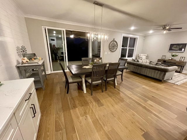 dining space featuring ceiling fan with notable chandelier, light hardwood / wood-style floors, and ornamental molding