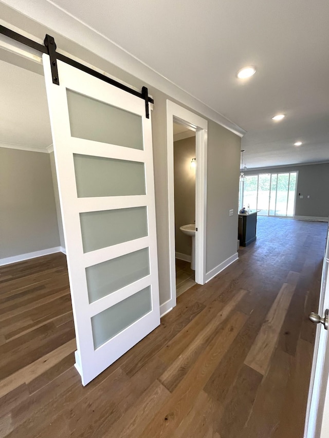 hall with a barn door, dark hardwood / wood-style flooring, and built in features