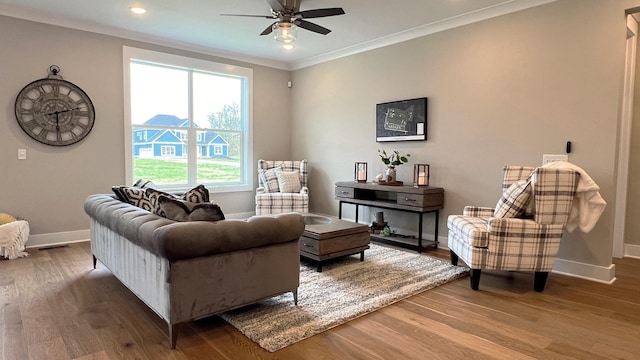 living area featuring crown molding, hardwood / wood-style floors, and ceiling fan