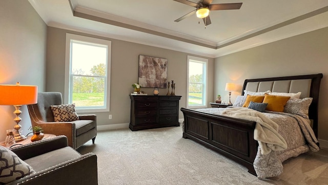 bedroom featuring ceiling fan, a raised ceiling, ornamental molding, and light carpet