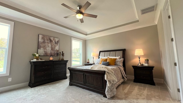 bedroom with light carpet, a raised ceiling, ceiling fan, and ornamental molding