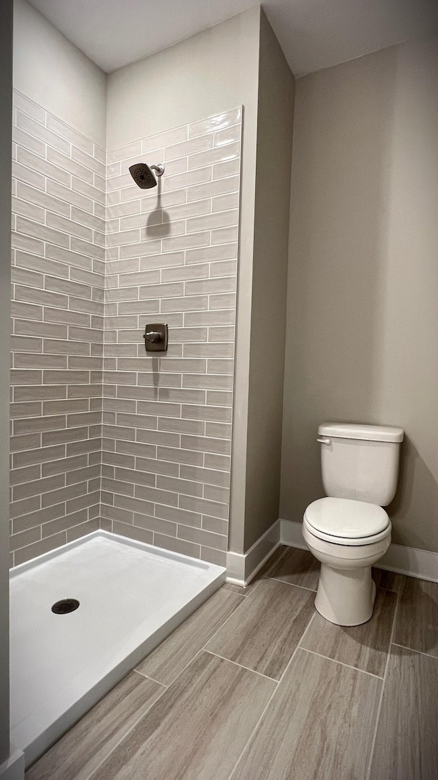 bathroom featuring toilet and tiled shower