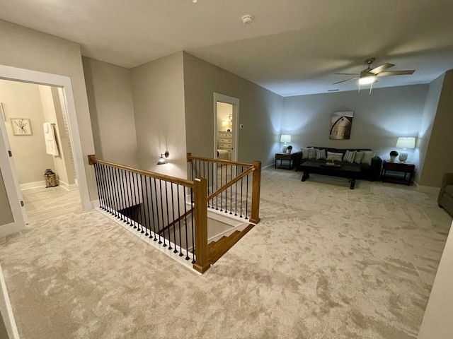 staircase featuring ceiling fan and carpet