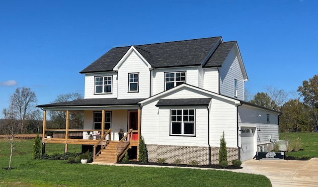 view of front of property with a garage, covered porch, and a front yard