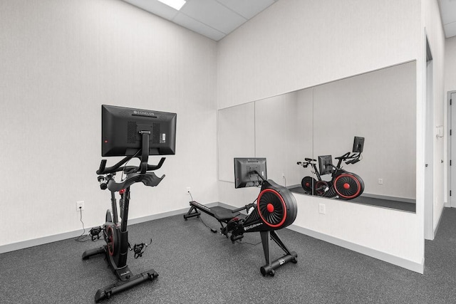 workout area featuring a drop ceiling and a towering ceiling